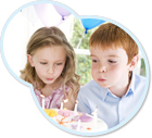 Kind bläst Kerzen auf einer Torte aus